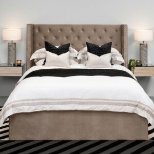 La Cama África combina calidez y elegancia en un tono beige neutro. Su cabecera capitoné con tachuelas y el diseño limpio de la base crean un ambiente acogedor y sofisticado. Los textiles en blanco con rayas beige y cojines negros completan un look equilibrado y moderno.