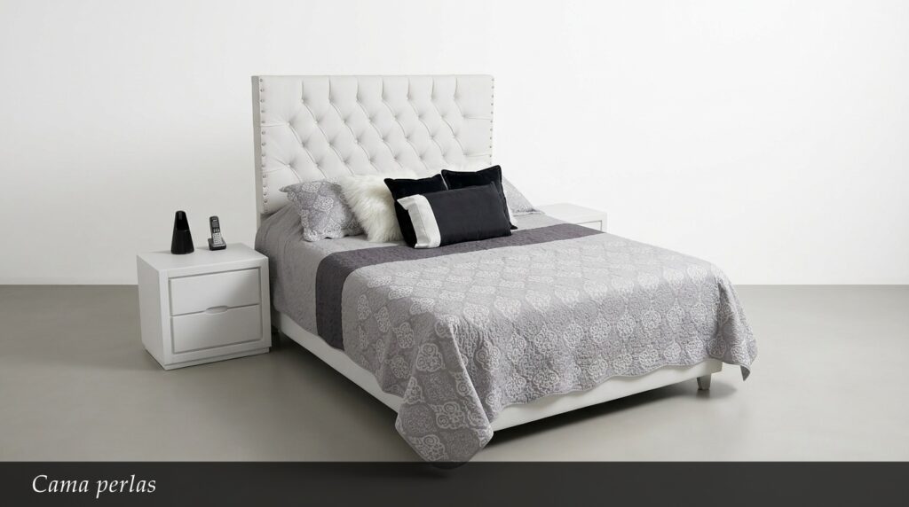 La Cama Perlas impresiona con su majestuosa cabecera blanca capitoné y detalles de tachuelas que recorren todo el perímetro. El contraste entre el blanco impecable y los textiles en gris y negro crea un ambiente refinado y lleno de estilo. Su diseño clásico actualizado la convierte en una pieza atemporal.
