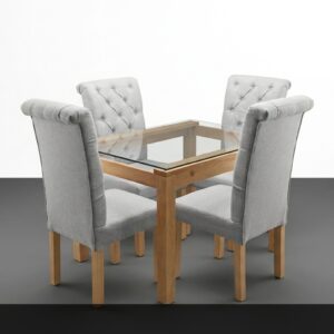 El Comedor Cristal combina la ligereza visual del cristal con la calidez de la madera. Su mesa con tapa de vidrio templado y estructura de madera clara aporta amplitud y luminosidad al espacio, mientras que las cuatro sillas tapizadas en gris claro con respaldo capitoné añaden confort y elegancia. El conjunto resulta refinado y contemporáneo.
