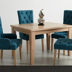 El Comedor Nu representa lujo y confort en su máxima expresión. Sus cuatro sillas tapizadas en un hermoso terciopelo azul turquesa con acabado capitoné y tachuelas decorativas aportan un toque de distinción y sofisticación. La mesa de madera clara de líneas rectas y sólidas completa un conjunto que irradia elegancia.